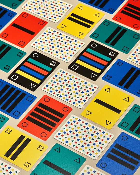 Close-up of playing cards with colorful abstract symbols and numbered triangle icons