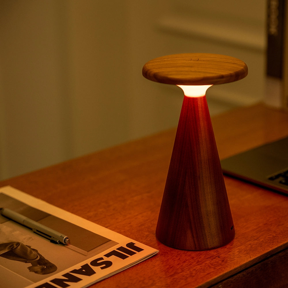 Large wood table lamp with white shade and dark fluted pedestal base, warm lit
