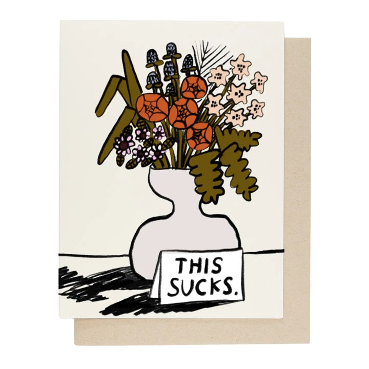 White greeting card with illustrated vase and text "THIS SUCKS"