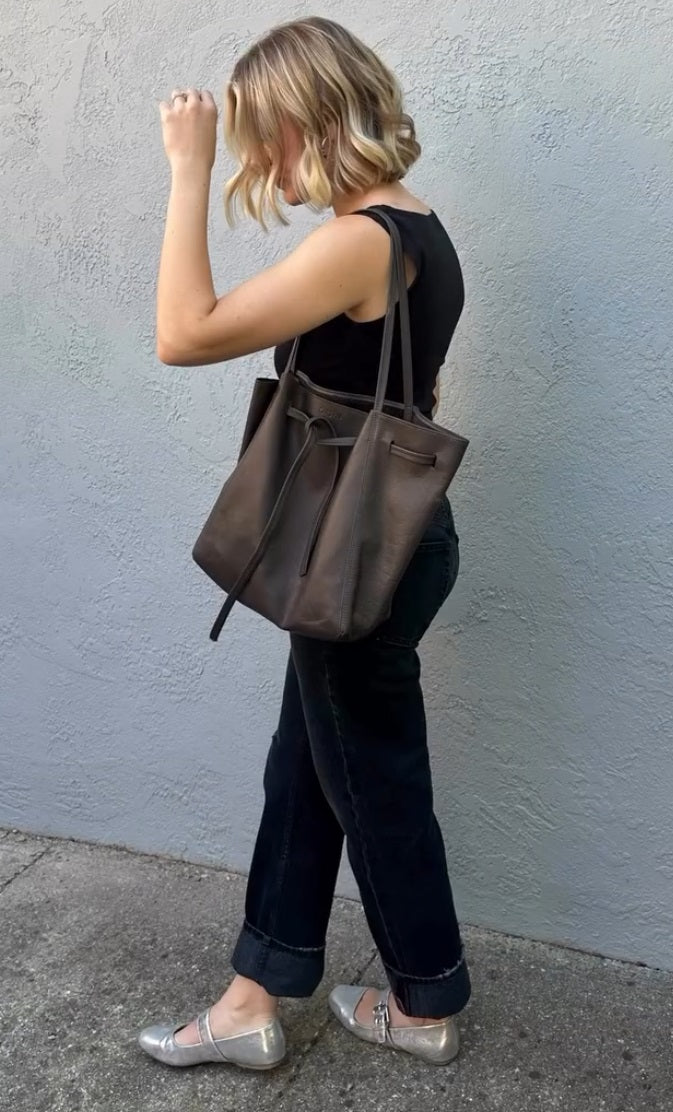 Charcoal leather tote bag with long shoulder straps and drawstring top