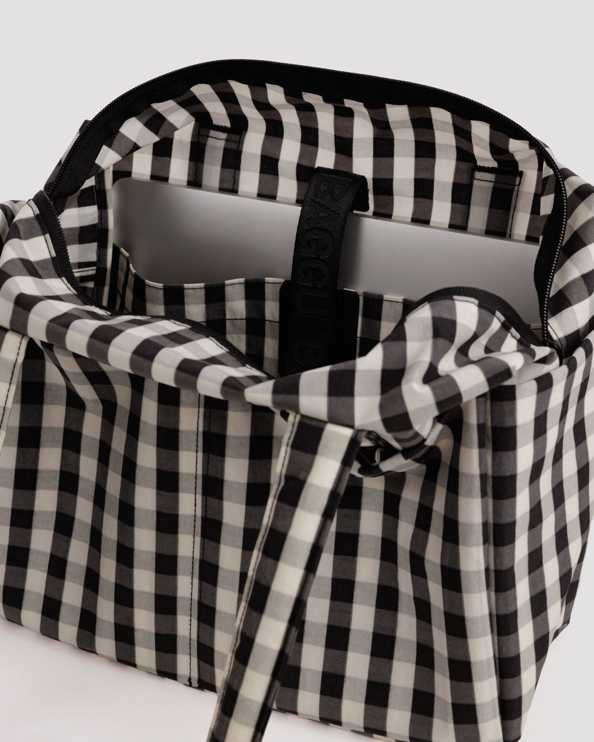 Black and white gingham tote bag close-up with handle and zipper