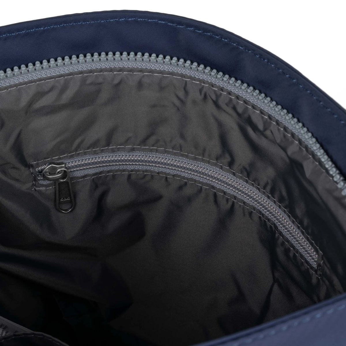 Dark blue crossbody bag interior showing zippered lining and gray zipper