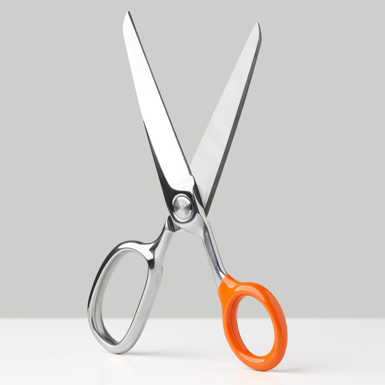 Stainless steel scissors with orange plastic finger loops