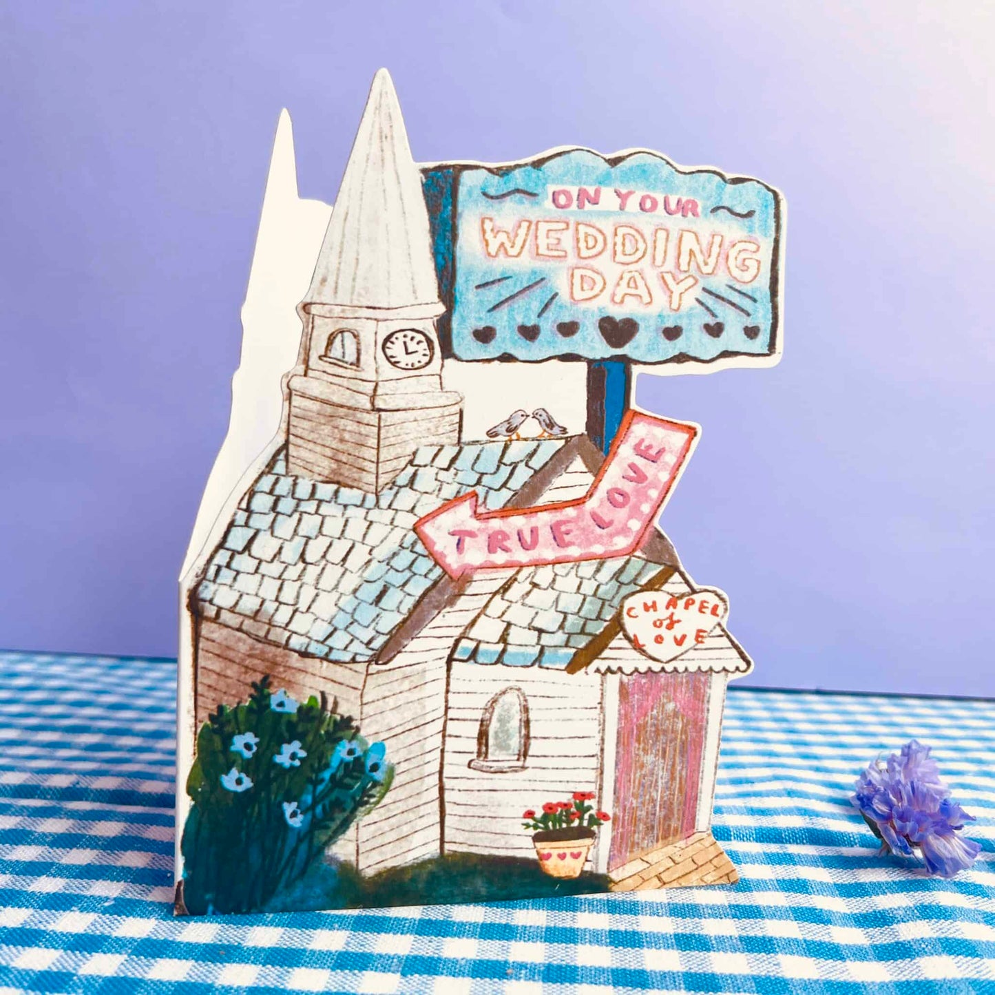 Wedding chapel greeting card with illustrated church, blue sign, and bride-to-be ribbons