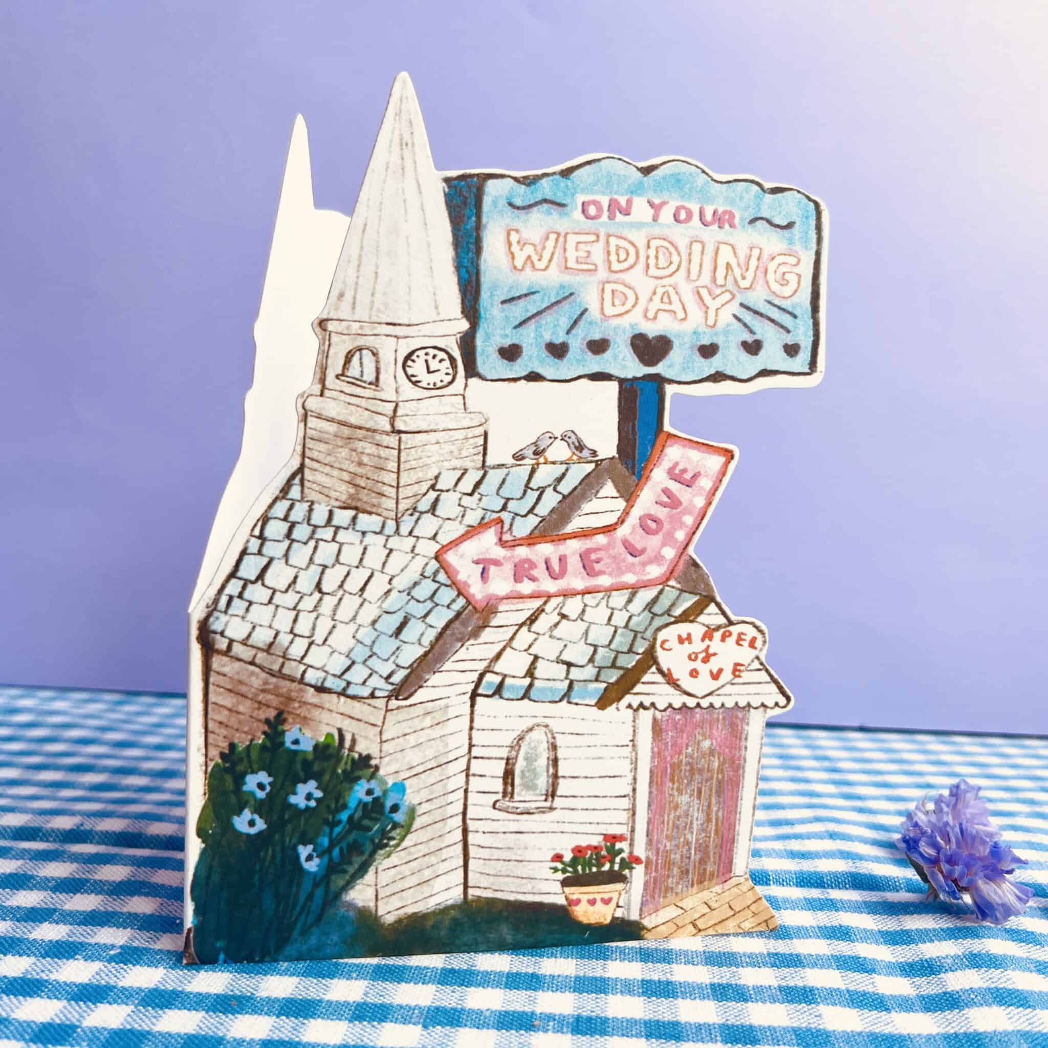 Wedding chapel greeting card with illustrated church, blue sign, and bride-to-be ribbons