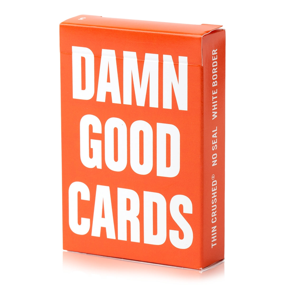 Orange playing card deck box with large "DAMN GOOD CARDS" text and vertical logo