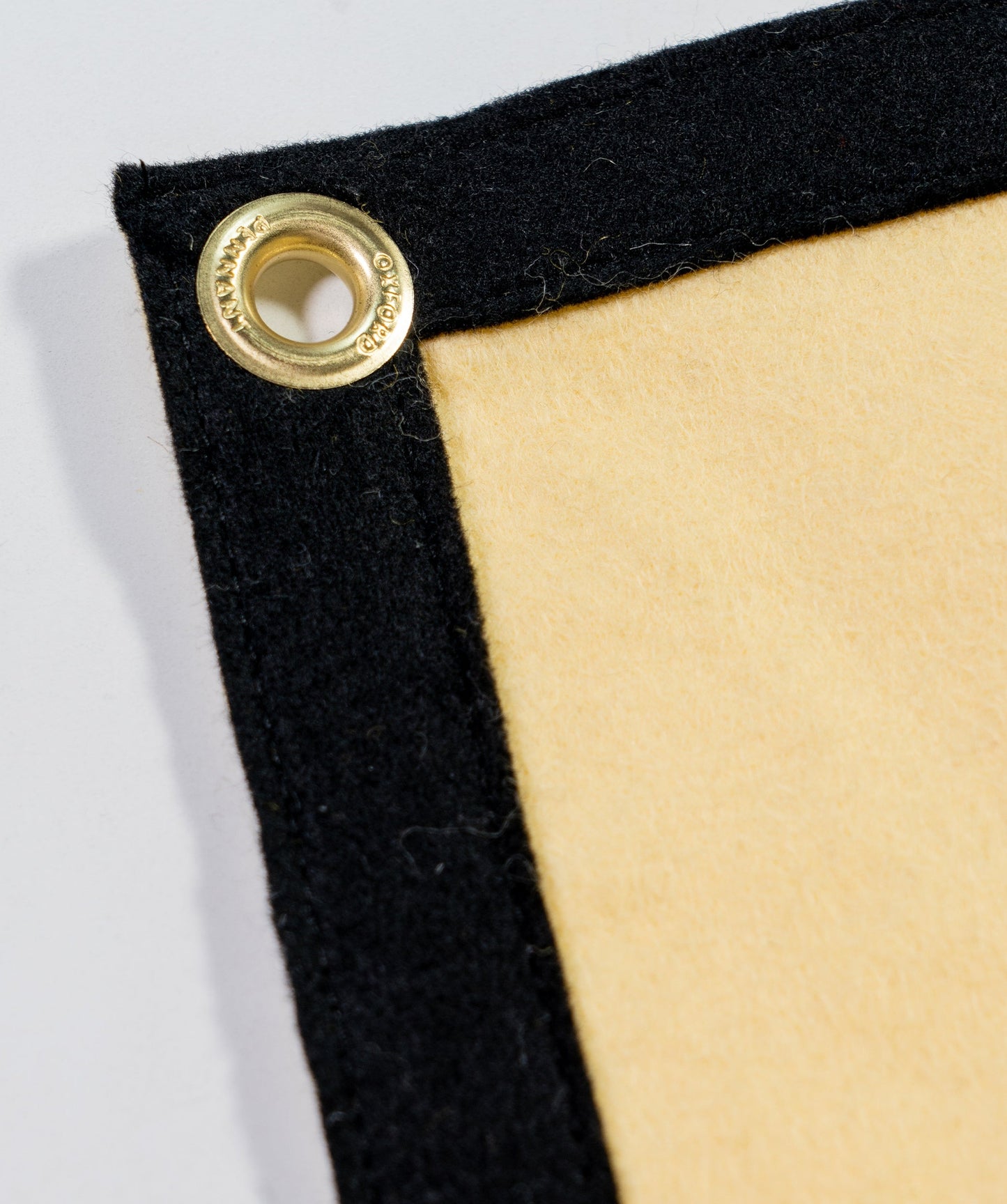 Close-up of camp flag corner with metal grommet on black felt edge