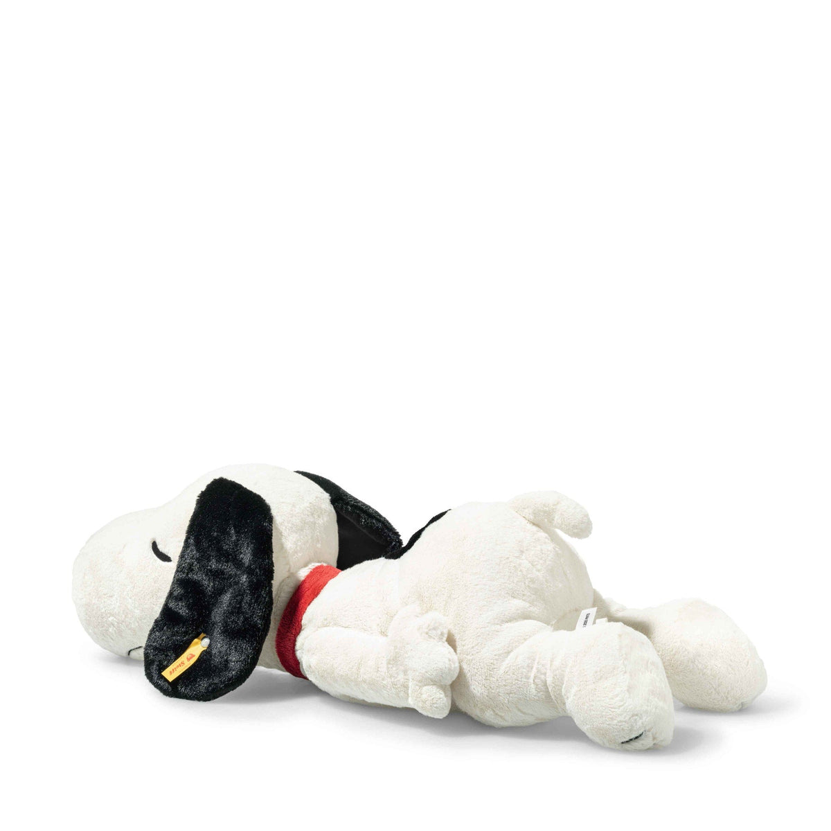 Snoopy plush lying down, white body with black ears and red collar detail