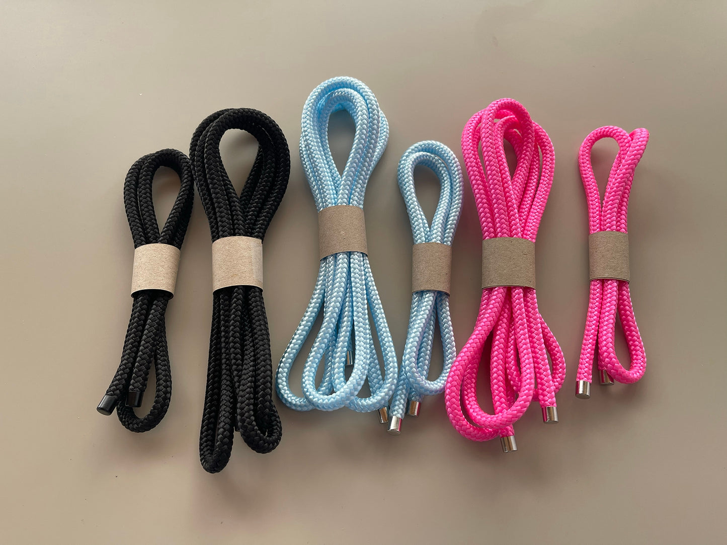 Cord set with braided cords in black, blue, and pink, with metal tips and loops