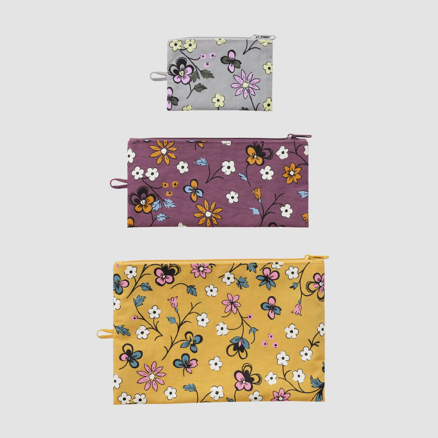 Set of three flat zip pouches with floral prints: light gray, purple, and yellow