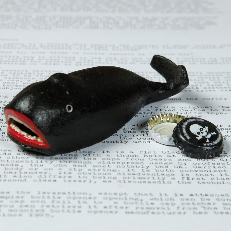 Dark whale-shaped bottle opener with red-lined open mouth and metal opener slot