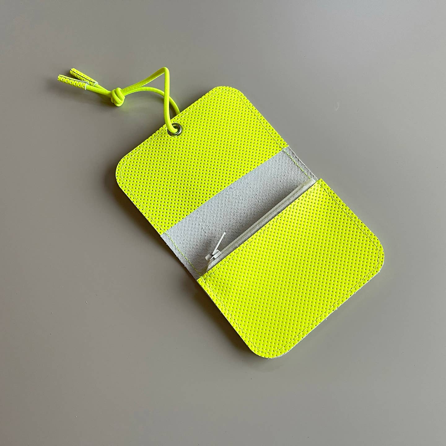Neon yellow leather mini wallet opened to show card slots and bill compartment