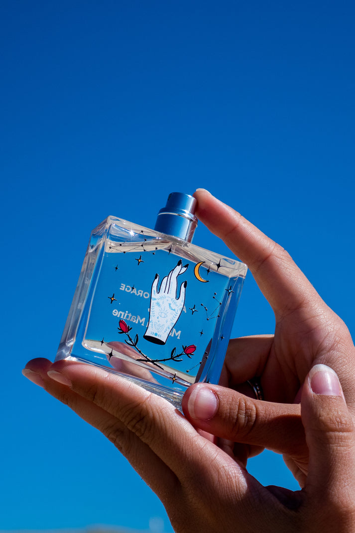 Avant l'Orage eau de parfum bottle held in hand, clear glass with illustrated label