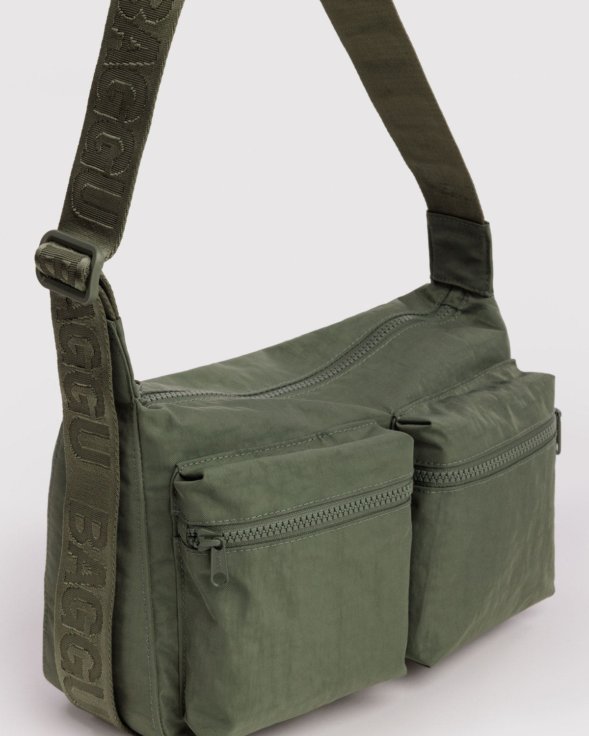 Olive green medium cargo crossbody bag side view with front zip pocket and strap.