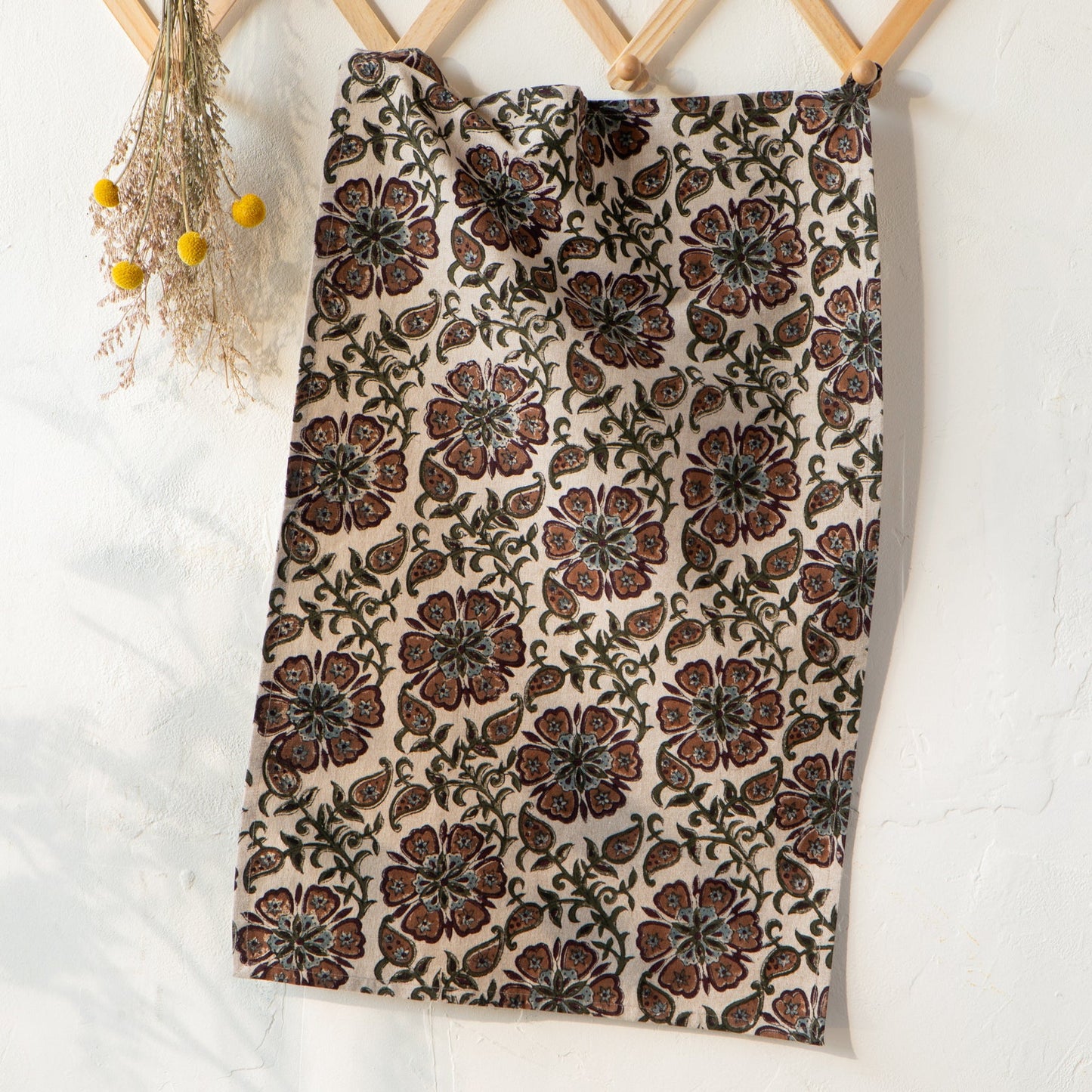 Hanging floral block-print dishtowel in cream with brown, rust, and green pattern
