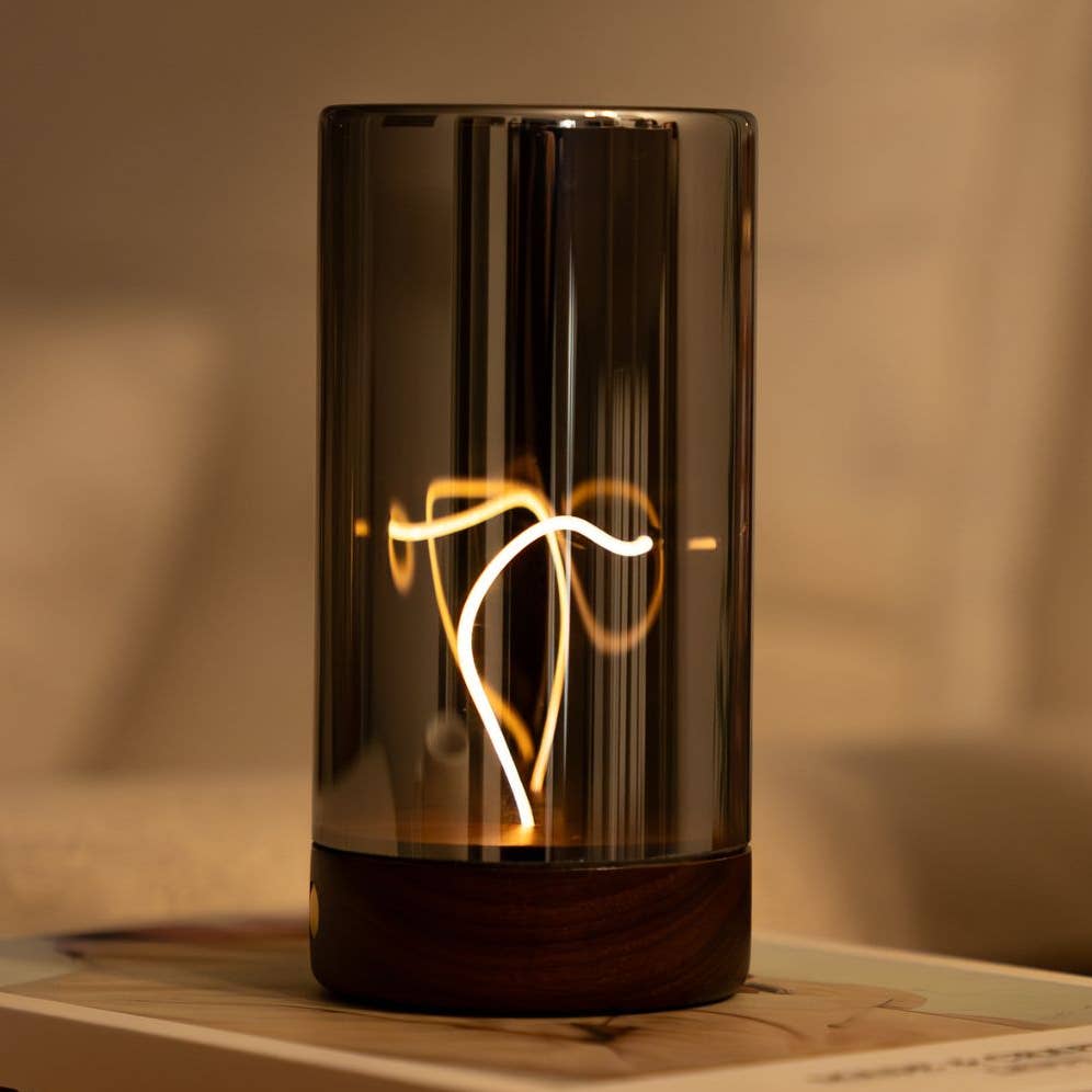 Solis Drift Light cylindrical glass table lamp with warm amber glow and dark walnut base