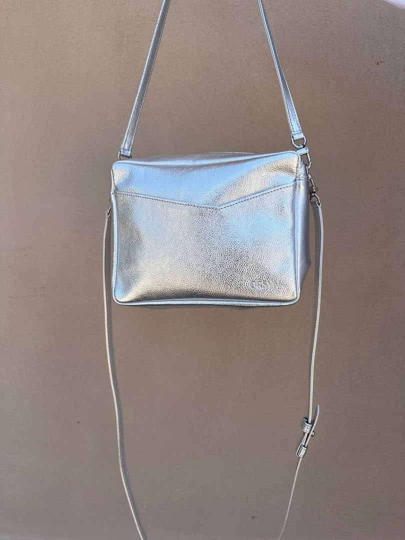 Silver metallic crossbody bag with zip top and adjustable shoulder strap