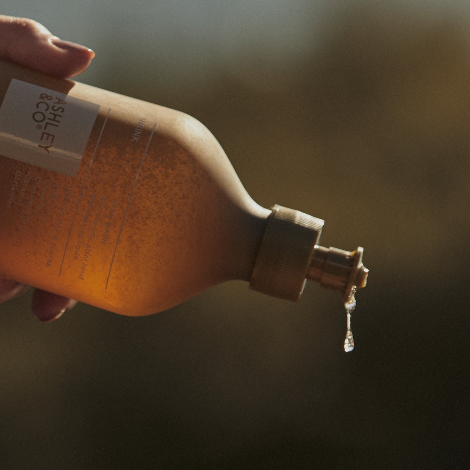 Dish wash bottle with flip-top spout dispensing liquid