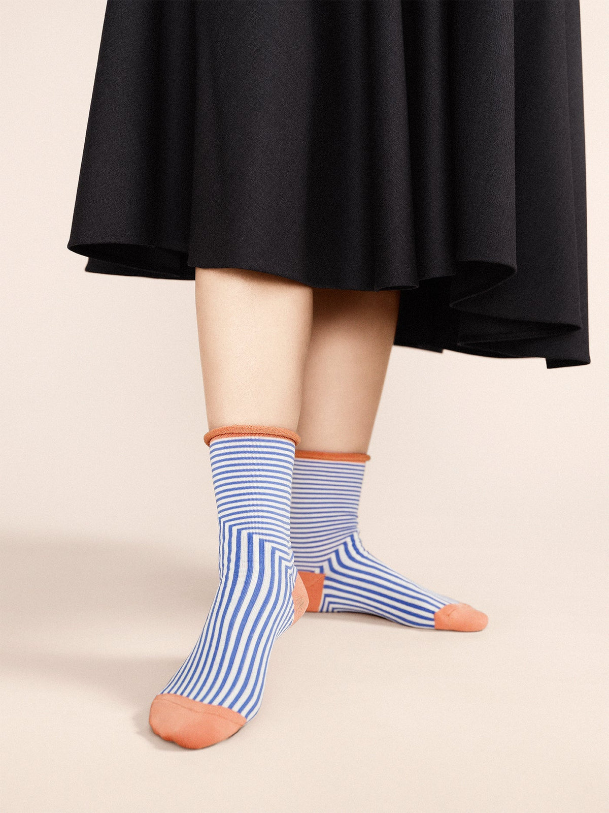 Crew socks in cornflower blue with orange toe and heel, worn with striped shafts