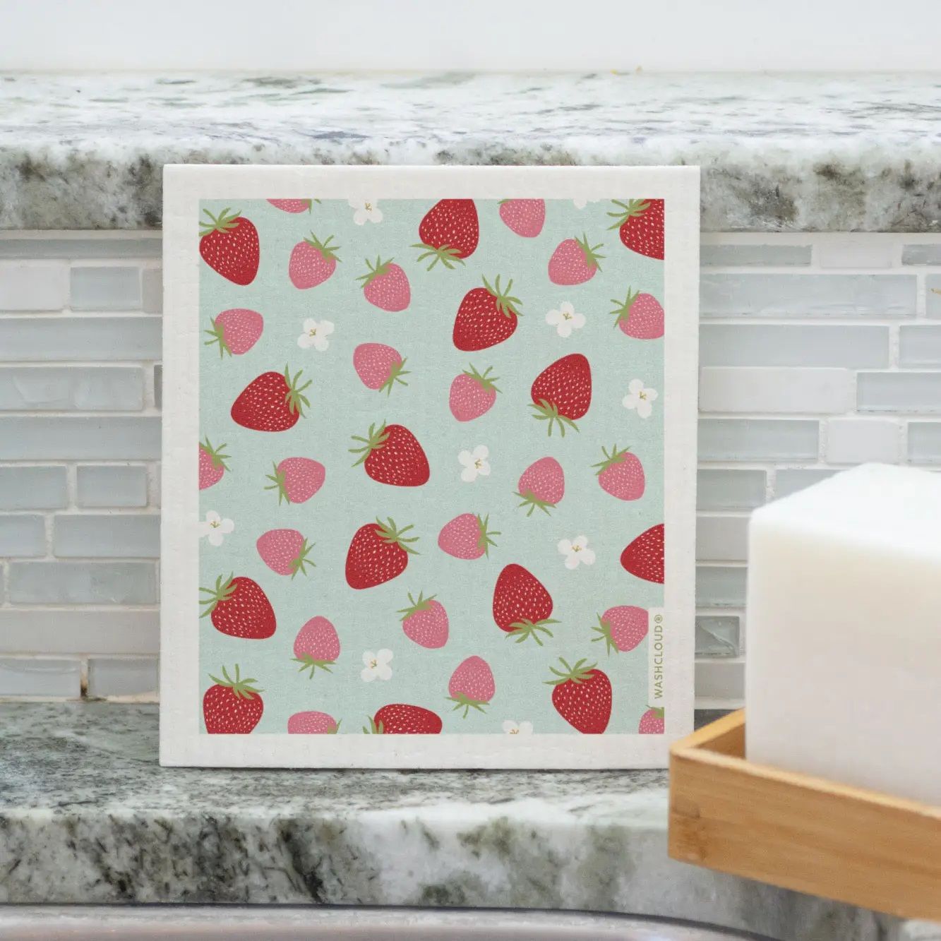 Dish washing sponge cloth featuring a scattered strawberry print with pink fruit