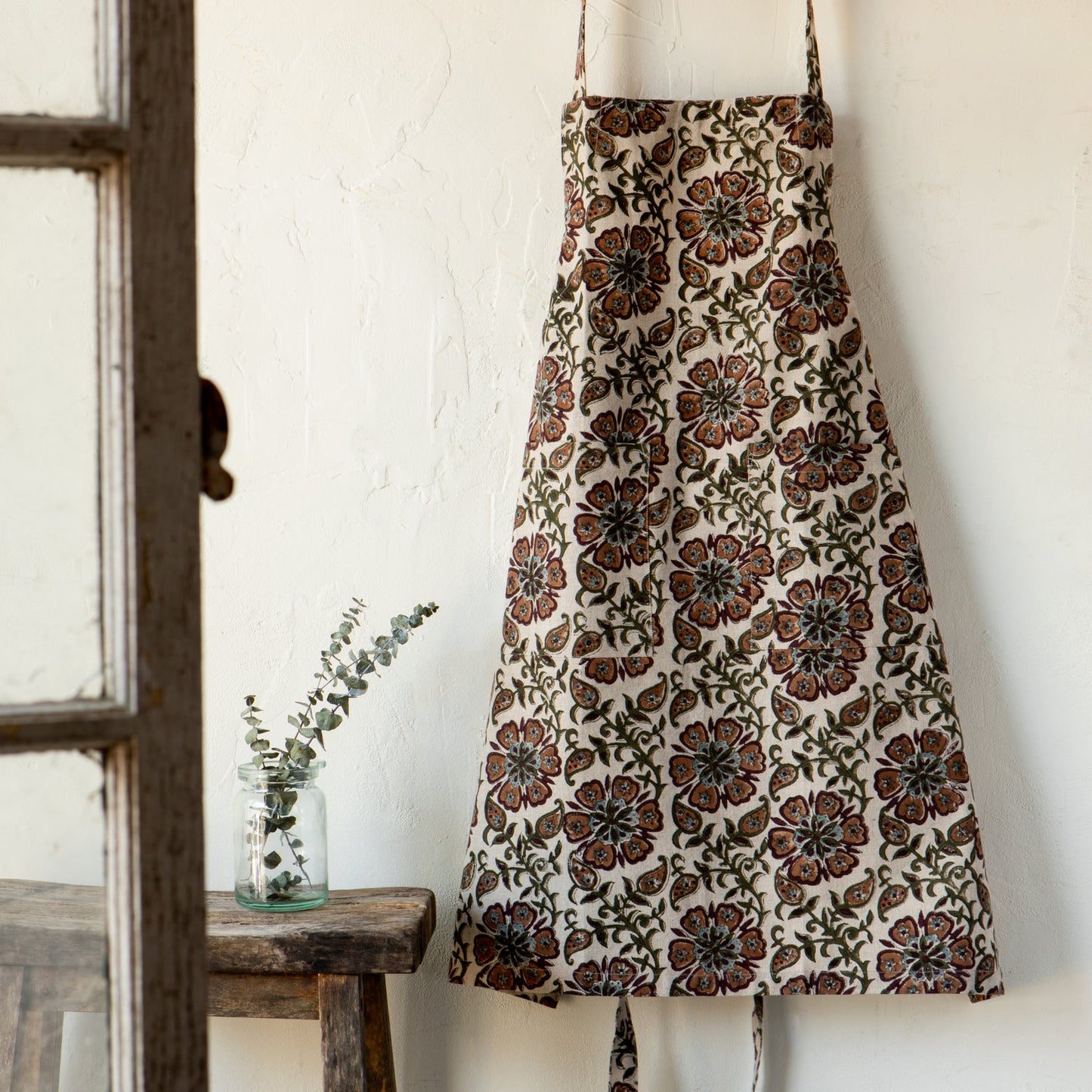 Cream floral block-print apron with tie straps, gathered waist and full skirt