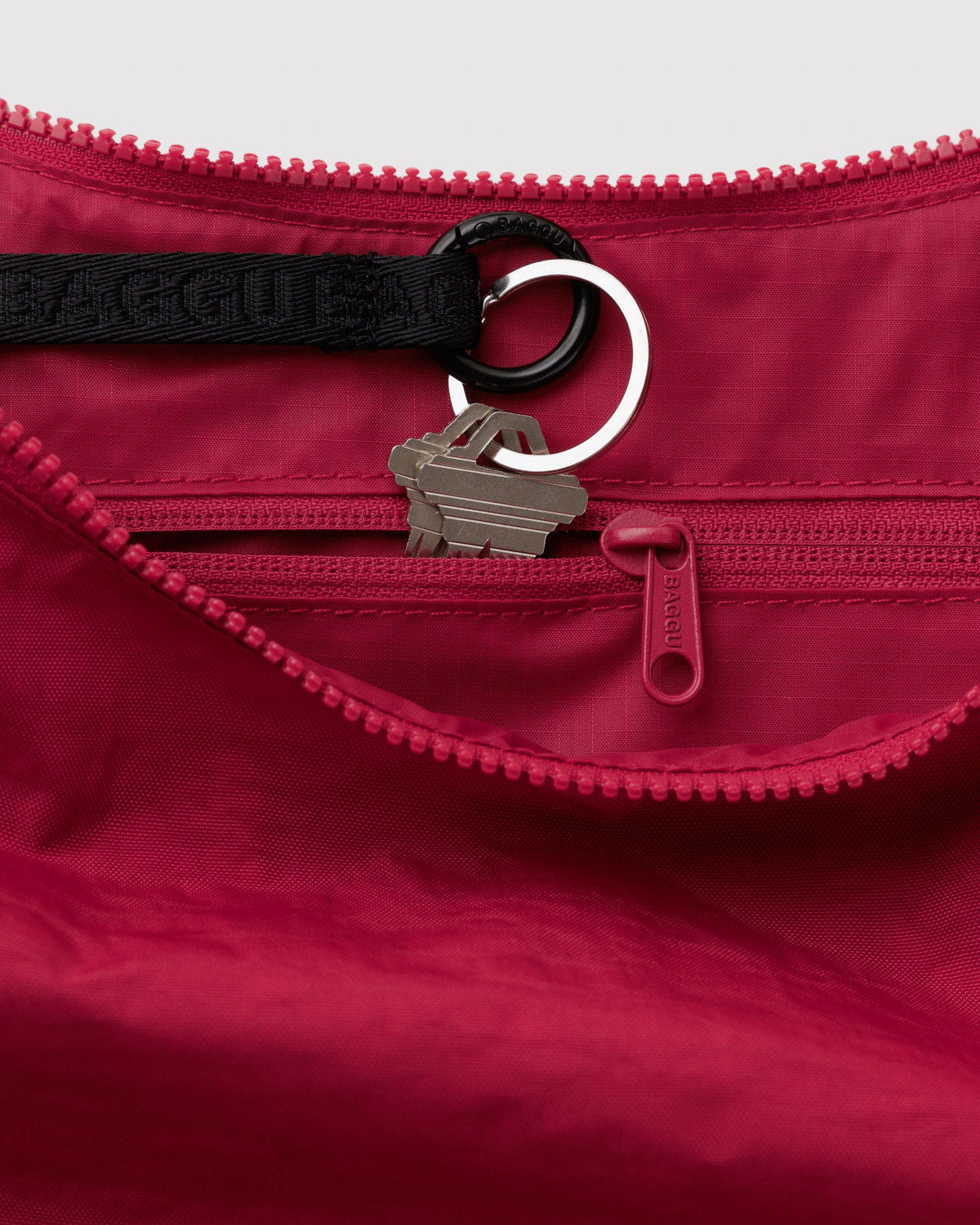 Medium nylon crescent bag interior in deep red with zipper pull and key ring