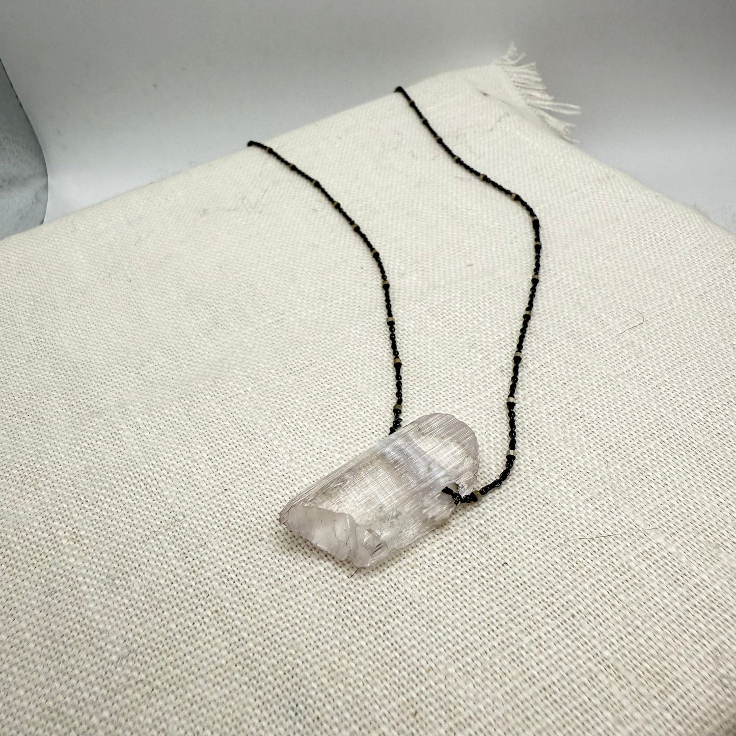 Oxidized sterling silver necklace with clear kunzite pendant on black chain