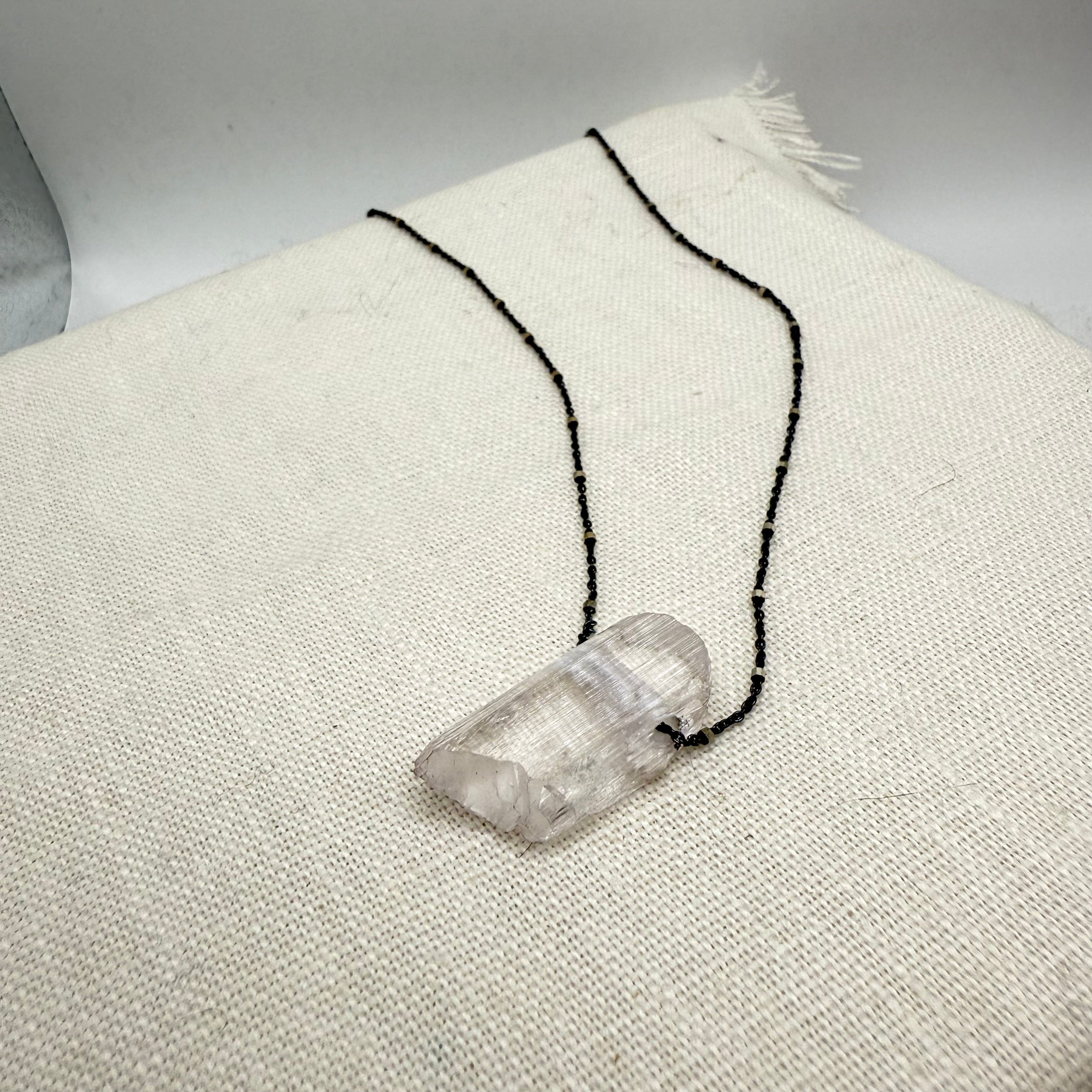 Oxidized sterling silver necklace with clear kunzite pendant on black chain