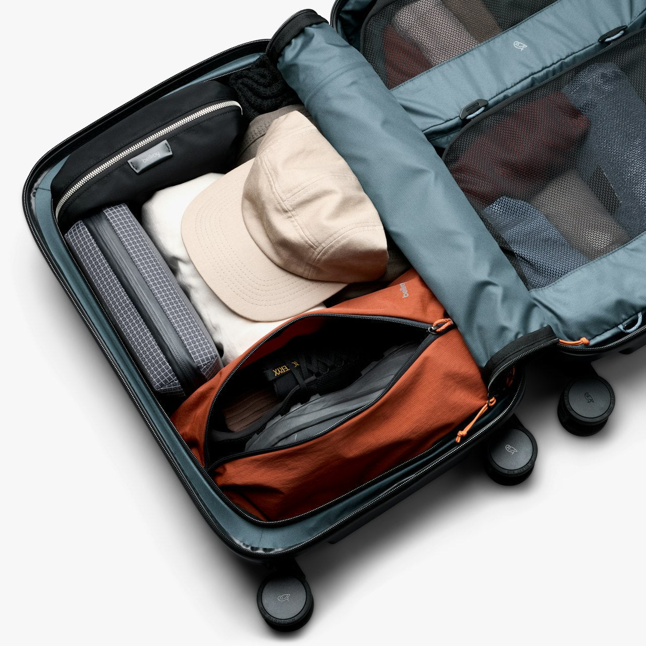Open black carry-on suitcase interior with mesh panels, pockets, and folded items