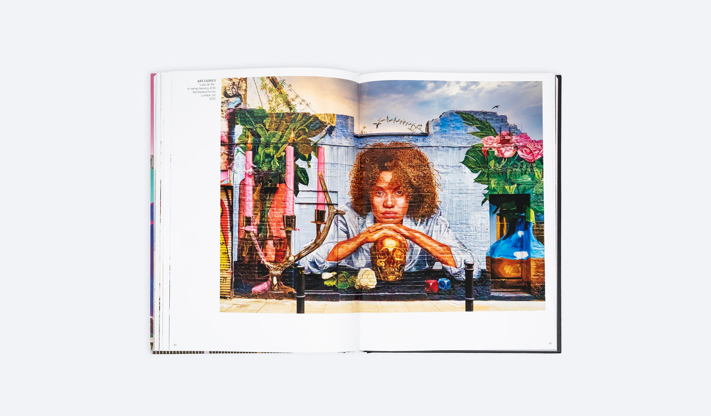 Open photo art book spread with a seated woman posing at a small tabletop