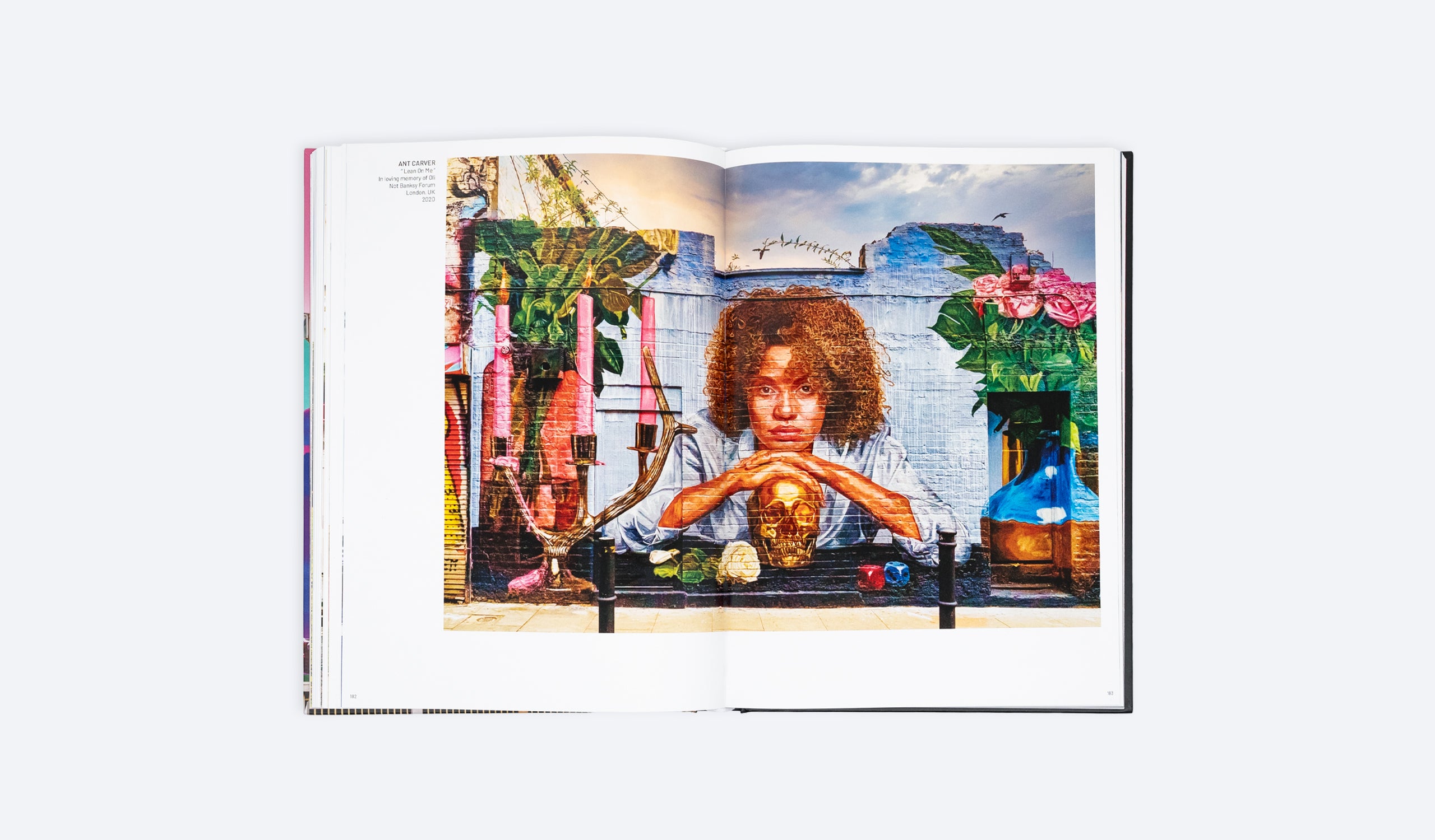 Open photo art book spread with a seated woman posing at a small tabletop