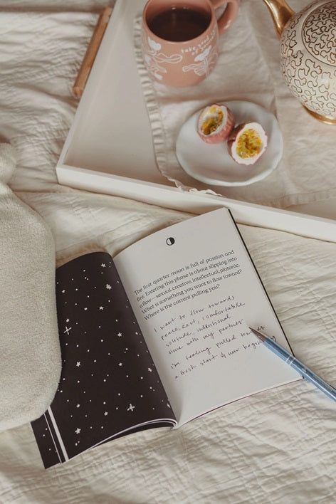 Open moon cycles guided journal with starry dark page and handwritten notes