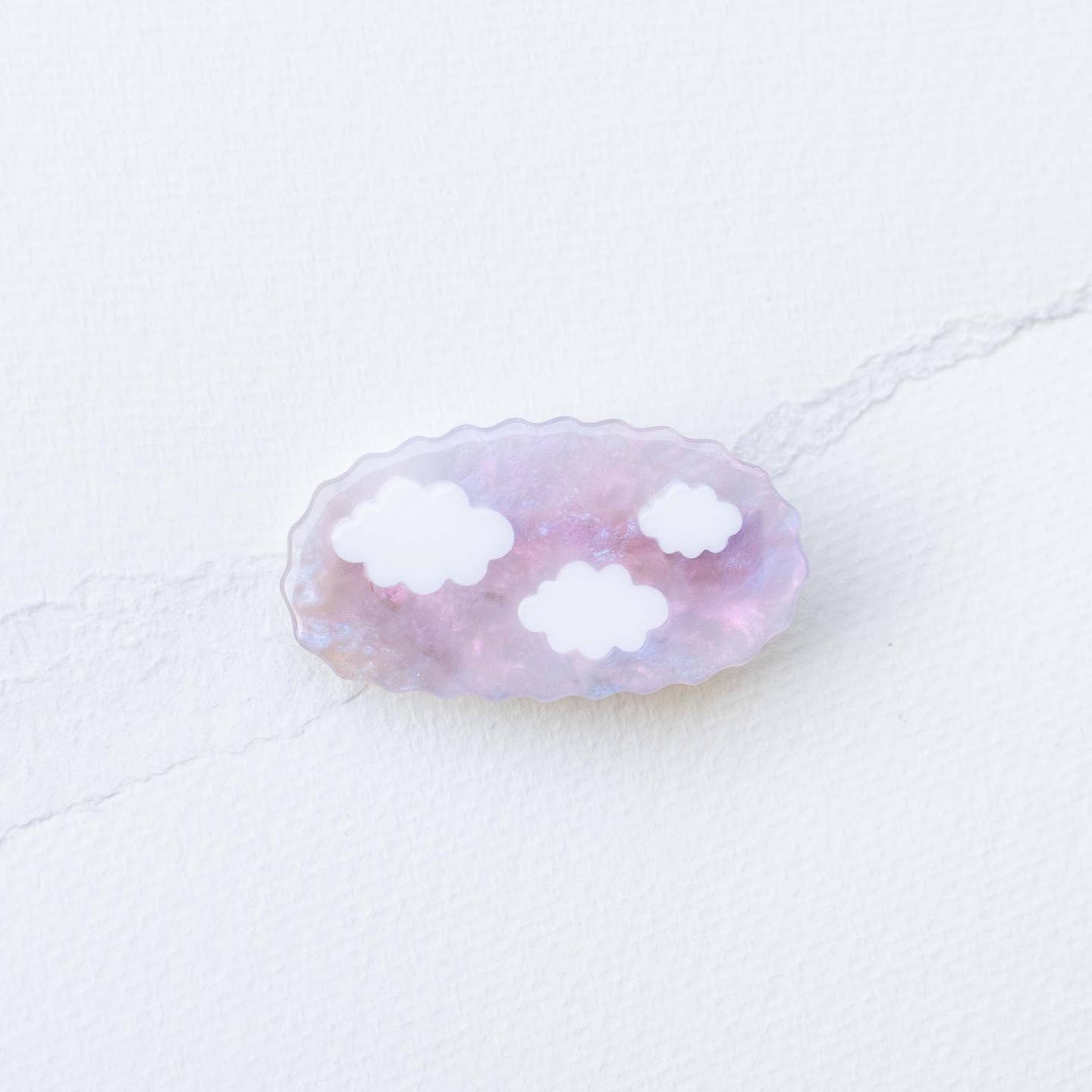 Translucent acetate hair clip with cloud-shaped cutouts in pink and lavender