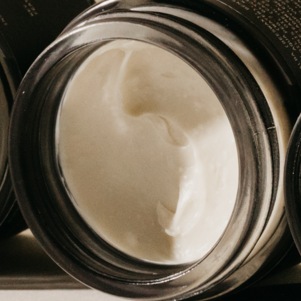 Unscented cream pomade texture in open jar, pale white cream