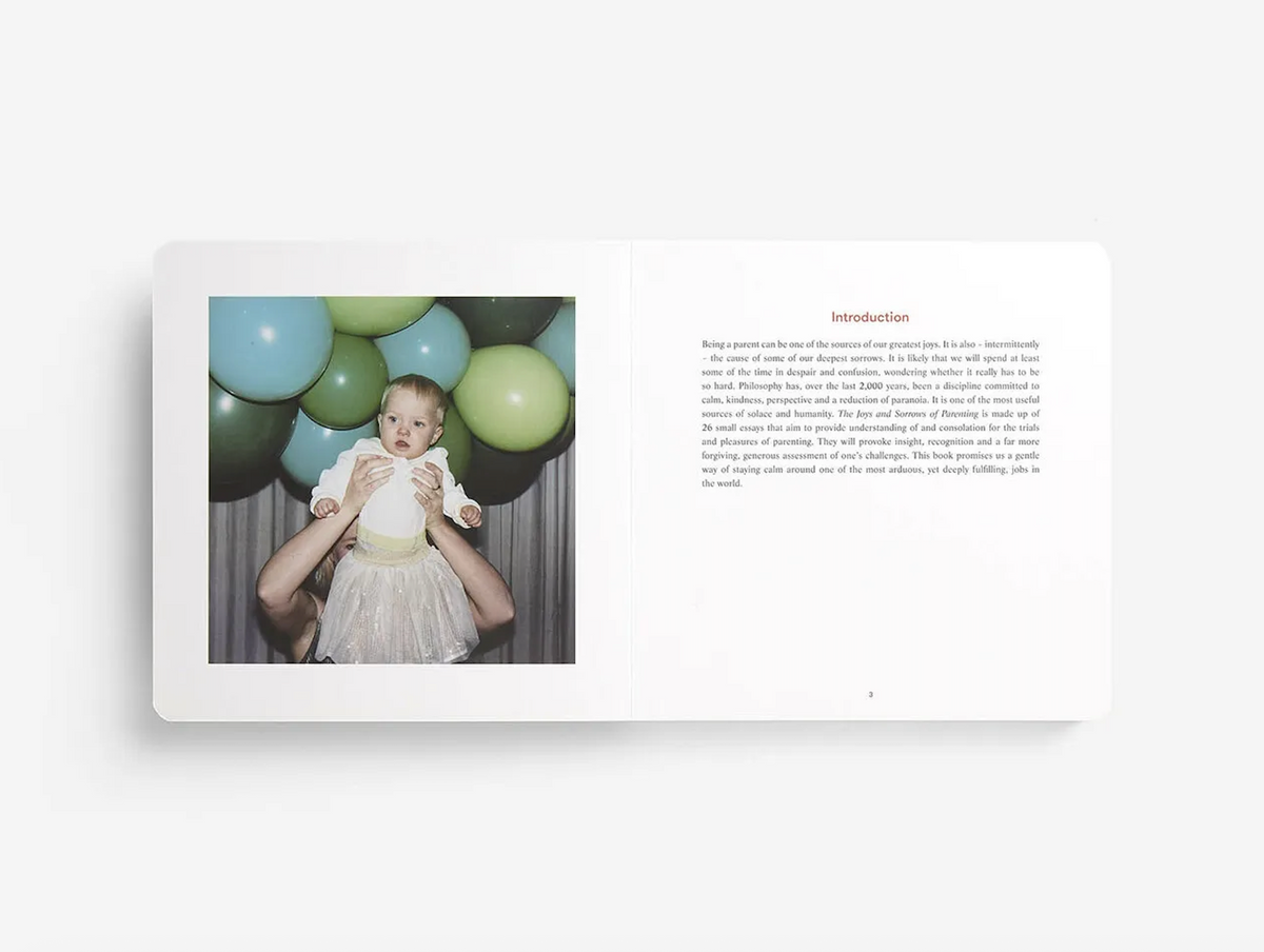 Parenting book open spread with baby in white dress and balloons