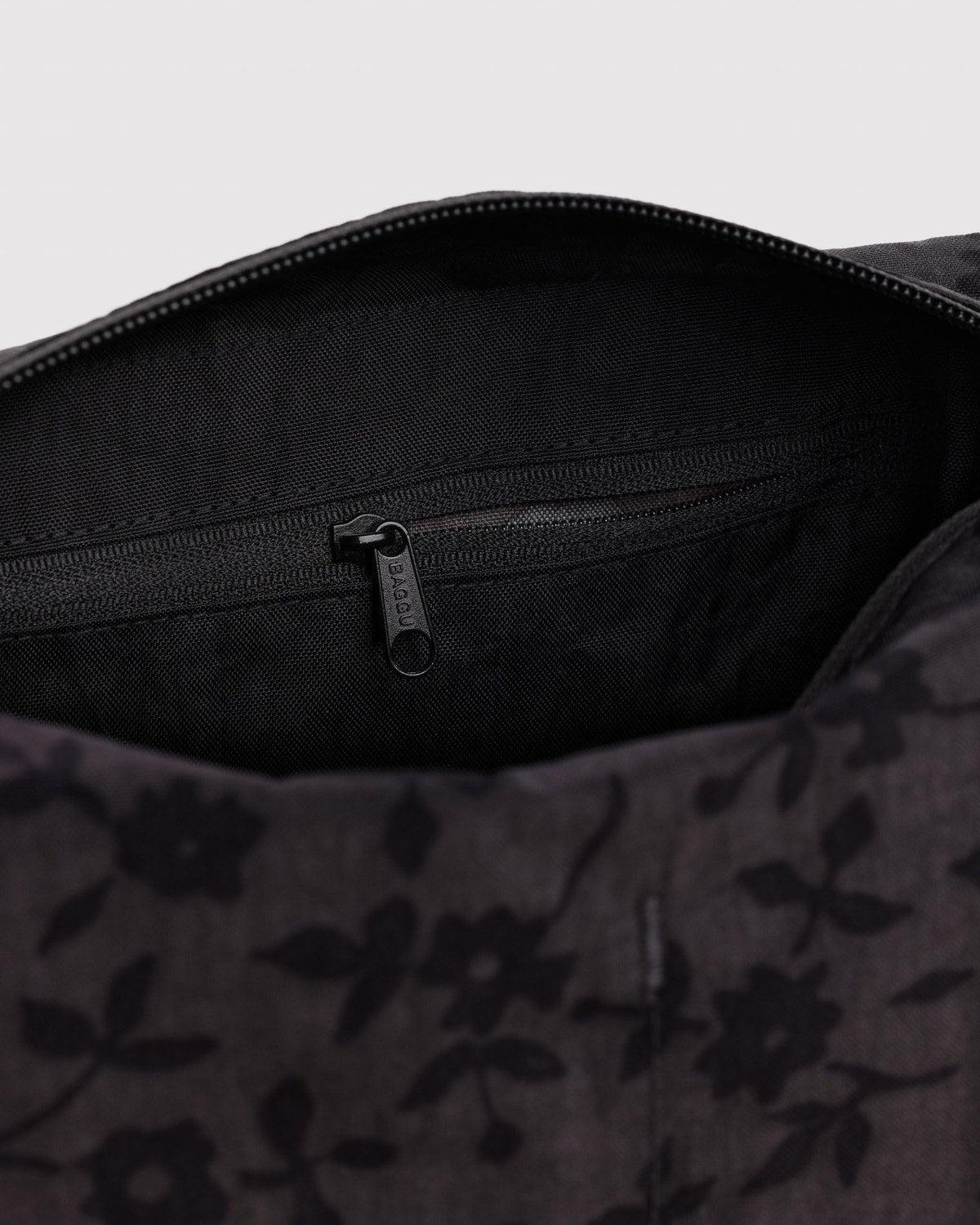 Black patterned dopp kit interior with dark lining and zipper pull