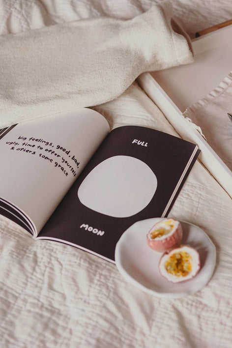Open moon cycles guided journal showing a black moon icon and full moon page details