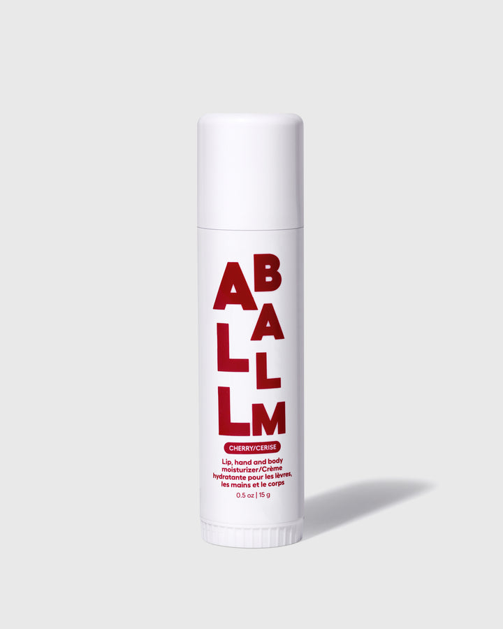 All balm stick with red label on a white tube and a twist-up cap.