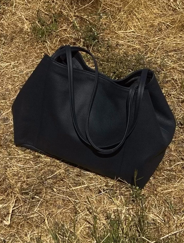Makena black pebbled leather tote bag, side view with two top handles