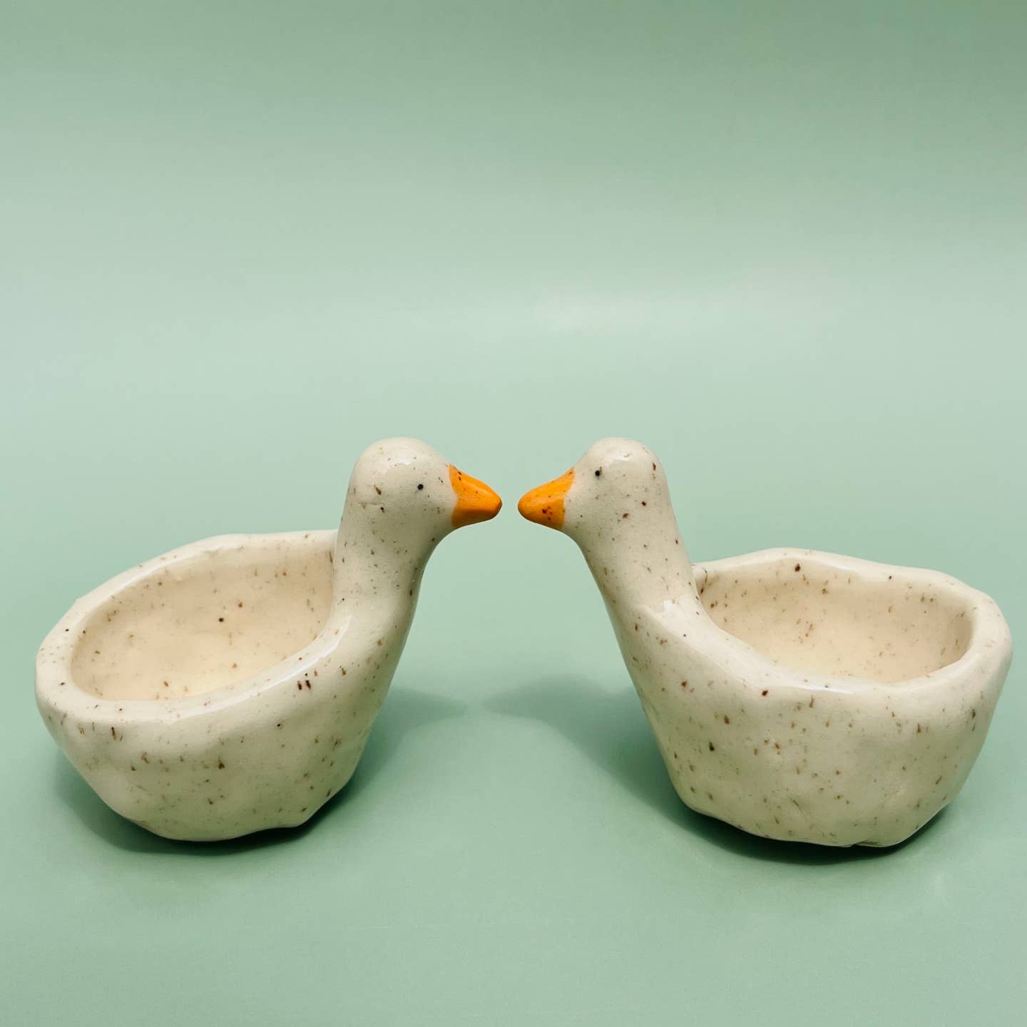 Goose-shaped ring dish with two speckled ceramic bowls and orange beaks for rings