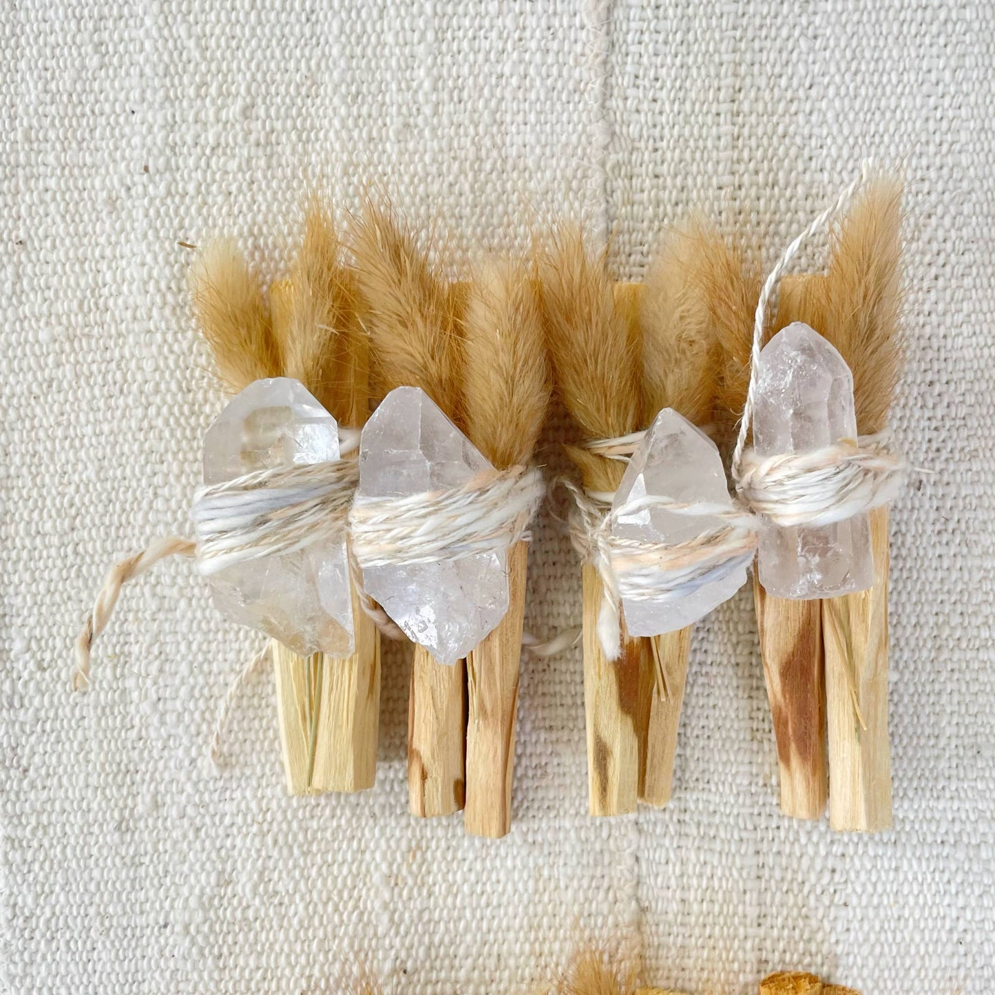 Palo santo bundle with several clear crystal points on tied short sticks