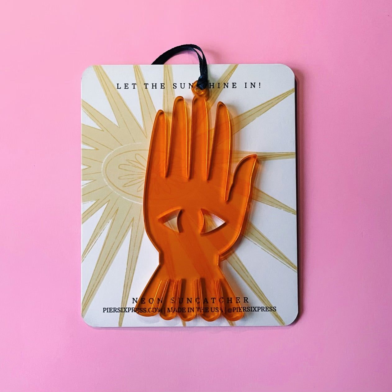 Neon acrylic suncatcher with orange helping hand and sunburst design