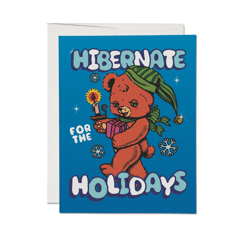 Sleepy teddy bear holiday card, blue front with bear holding candle; reads 'Hibernate for the Holidays'.
