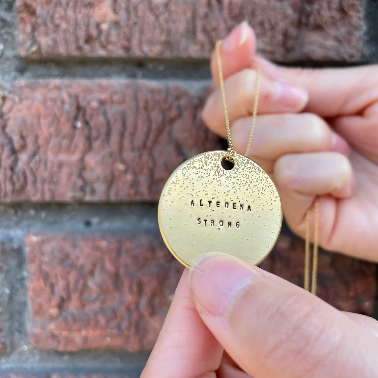 Gold round diamond-dusted pendant, 'Altadena Strong' text, black hole top