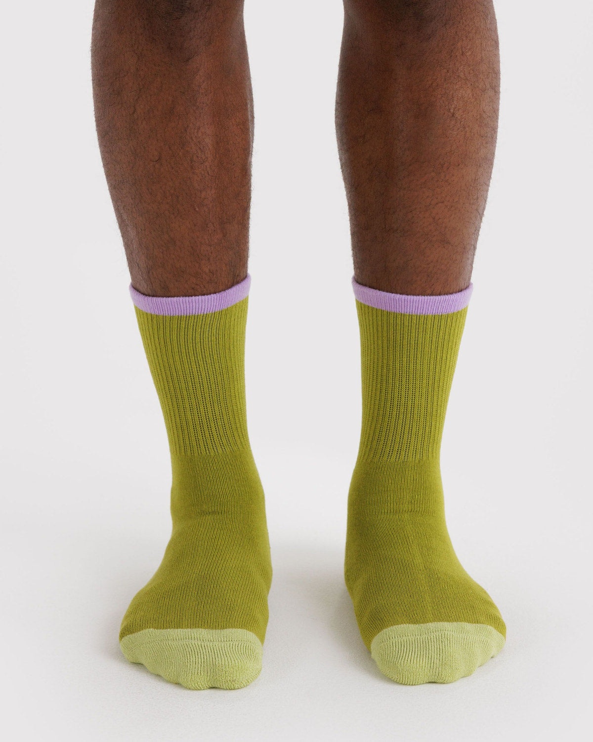 Ribbed olive green socks on feet with lilac cuff and rounded toe.