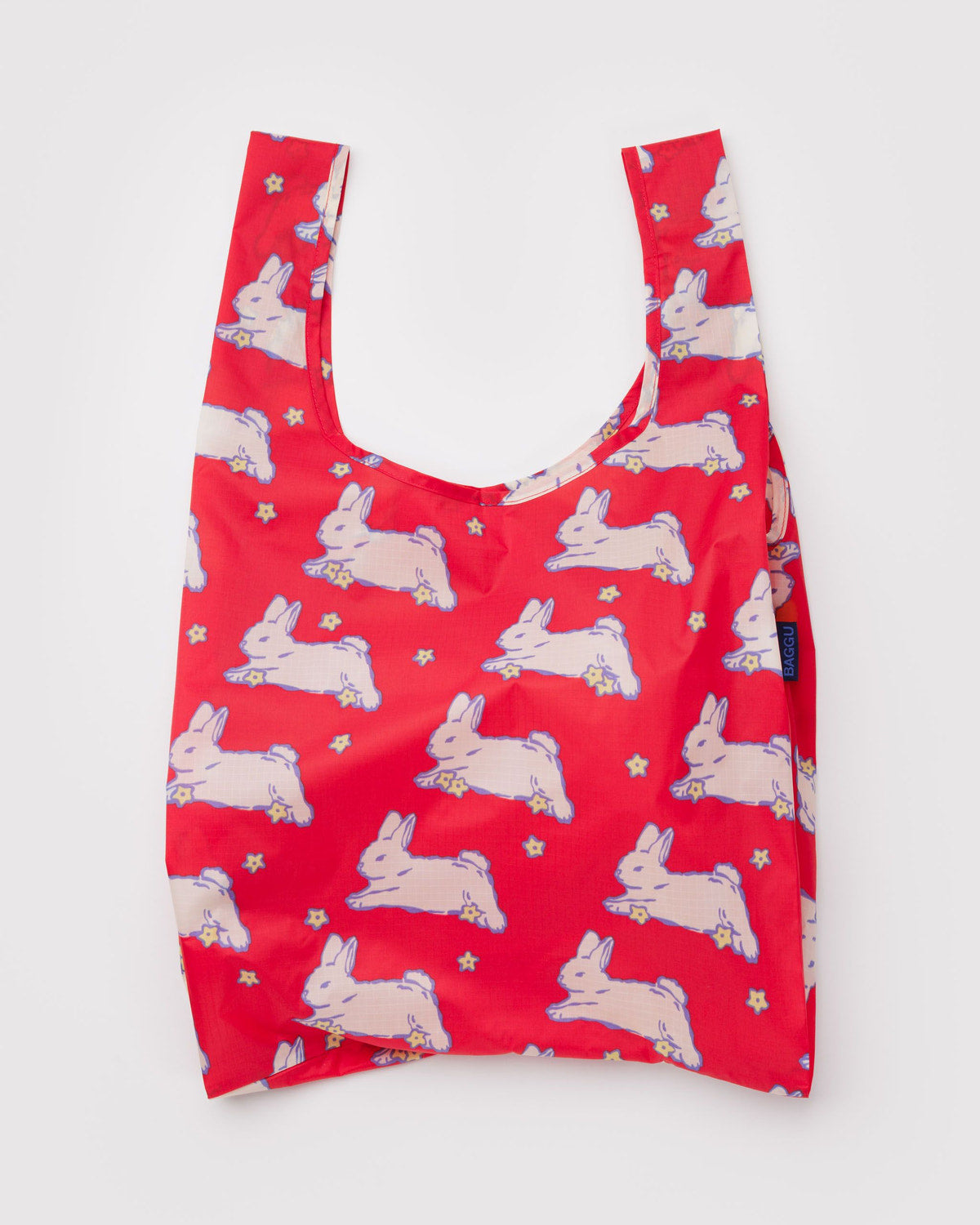 Reusable tote bag in red with repeating white rabbit print and short U-shaped handles.