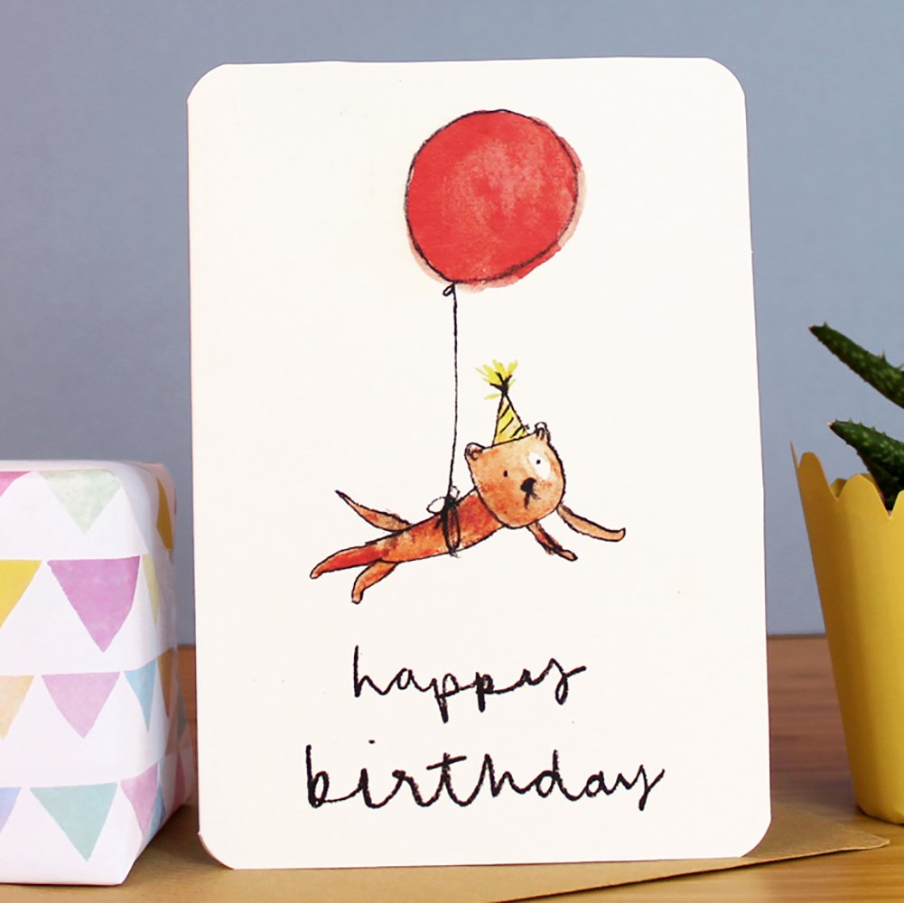 Birthday card featuring a cartoon dog holding a red balloon with 'happy birthday' text