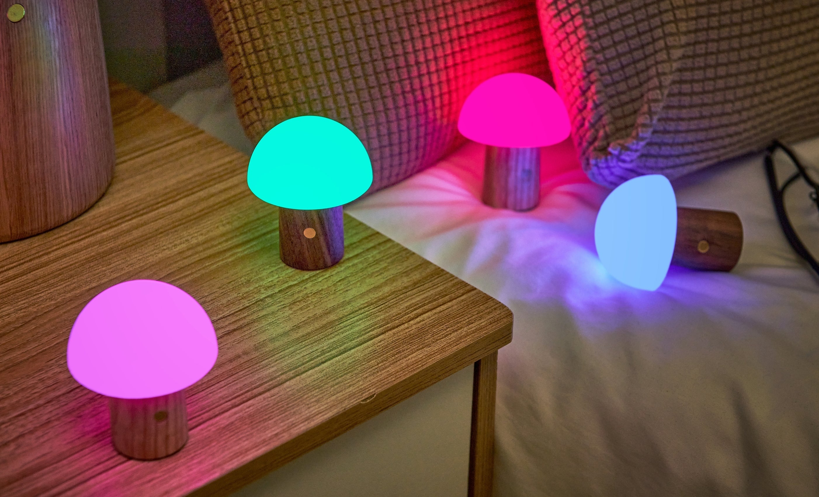Set of super mini walnut mushroom lamps with multicolor glowing caps on wood surface