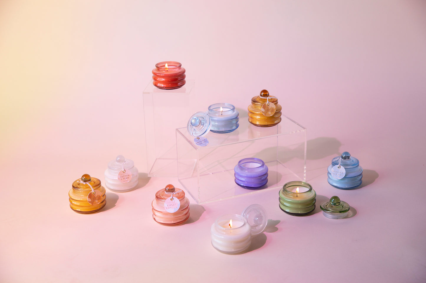 Beam candle set with assorted glossy glass jars on a clear acrylic display stand