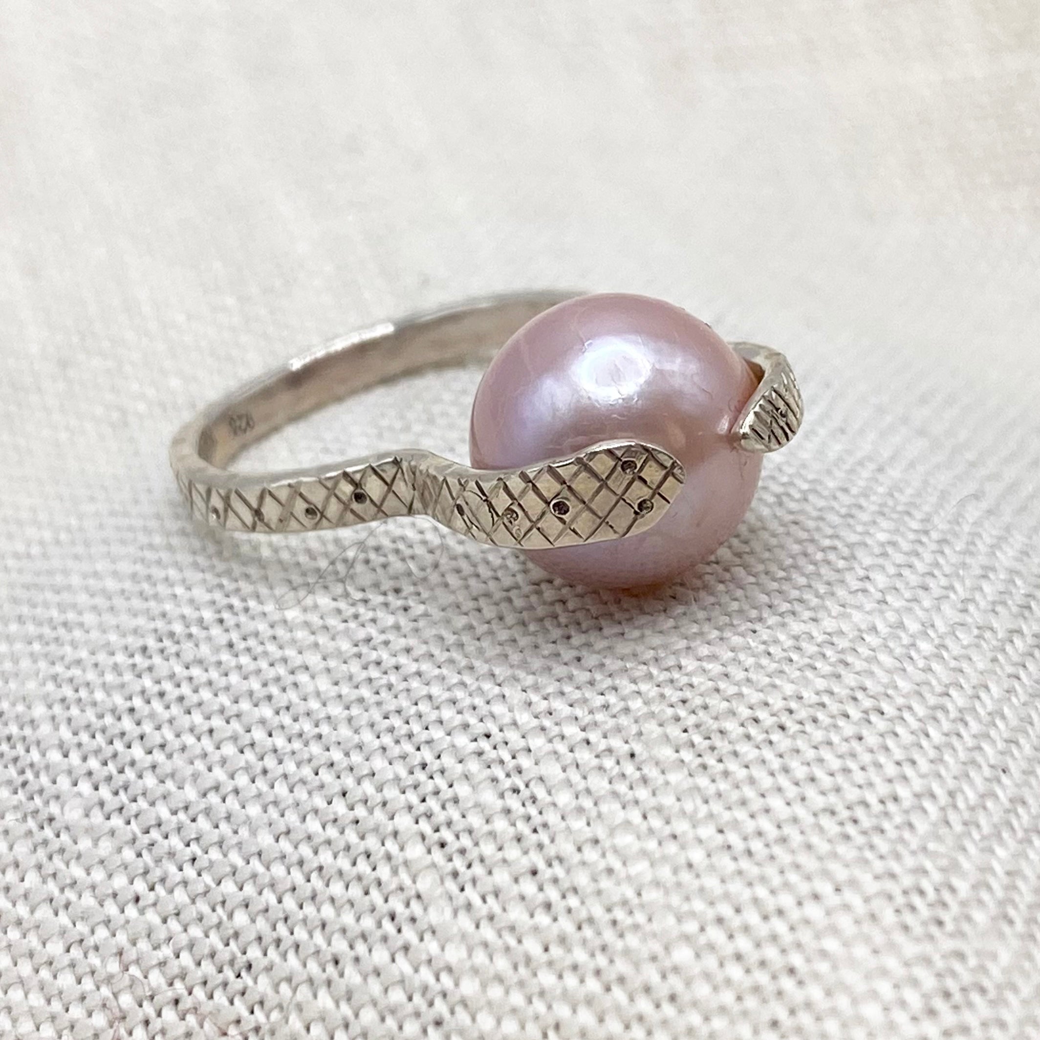 Sterling snake ring with blush pink pearl centerpiece, textured snake-pattern band